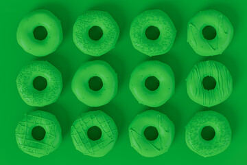 Fototapeta premium Isometric view of glazed donut with sprinkles on plain monochrome green color