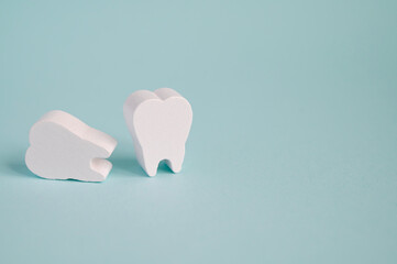 Toy wooden teeth on a turquoise background. Hygiene and dental care medical healthy lifestyle concept.	