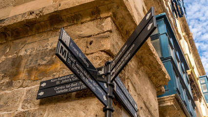 sign with street names on a limestone wall in Malta, Valleta