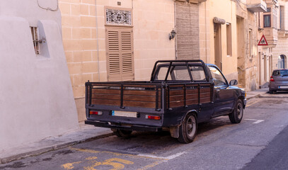 used pickup truck on the streets of an old European city in summer