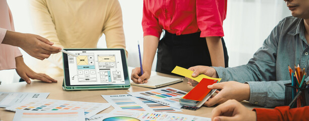 Cropped image of interior designer team discuss the material color while tablet displayed website...