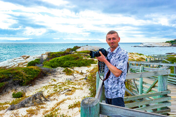 Tourist takes photo with penguins in Cape Town South Africa.