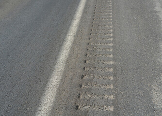 Rumble strips and white line on side of road.  Safety feature to keep drivers alert.