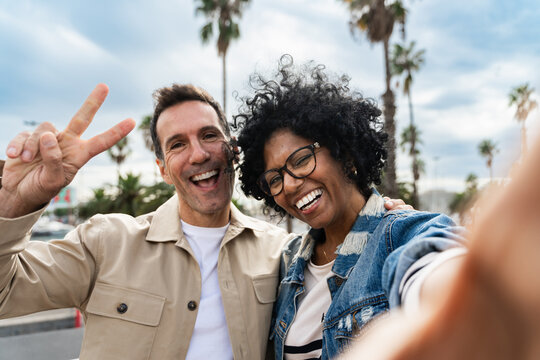 Selfie portrait of multiracial adult couple or friends having fun