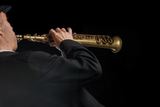 soprano saxophone in the hands of a guy on a black background
