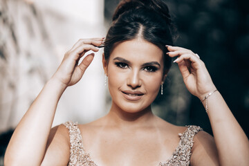 Obraz premium Close up portrait of a teen brunette girl in a golden dress. Ready for prom