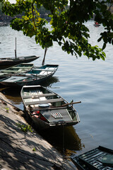 Dozens of tin row boats lined up tied together on shore in Tam Coc in the Ninh Binh region of Vietnam. Boat tours are a the main source of income for the workers in the region of the country.