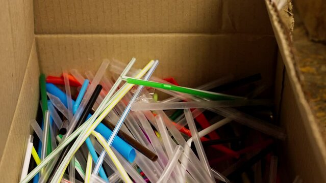 Close-up image of many colorful plastic used drinking straws stored at a recycling and waste sorting station