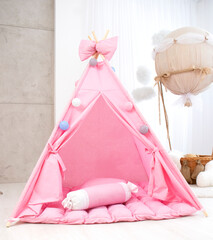 Playroom with Teepee. Modern room interior with play tent for child. pink children's wigwam in the room on the floor Scandinavian style with decor. High quality photo