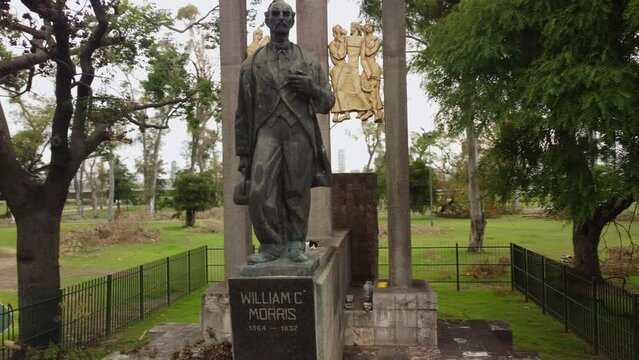 Panorama around the monument to William Morris, a black and white cat sits on the monument and looks at the camera