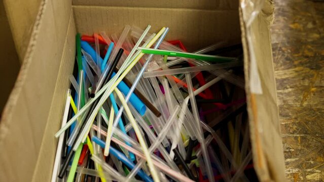 Close-up image of many colorful plastic used drinking straws stored at a recycling and waste sorting station