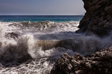 Large waves breaking over rocks - 738921772