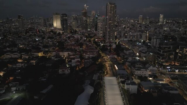 Night drone scene over illuminated Tel Aviv City with modern buildings in Israel