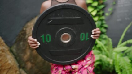 Bipoc woman in vibrant fitness attire performs barbell squats outdoors. Athlete lifts weights, focuses on strength training. Empowered female engages in heavy sport, striving for health, body goals. - Powered by Adobe