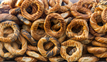 Ruddy baked bagels sprinkled with poppy seeds and sesame seeds.