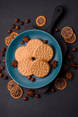 Round dotted snack snack cookies with cream on a dark concrete background