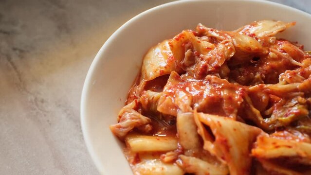 kimchi in fresh white bowl close-up on gray background