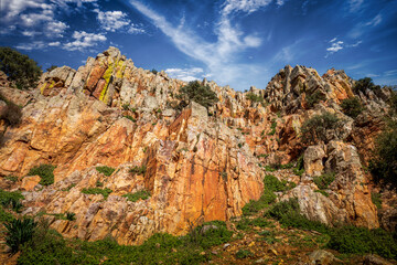 Wall of peculiar colorful rock in the Estrecho del Hocino micro-nature reserve in Salobre, Albacete, Castilla la Mancha, Spain on a bright day