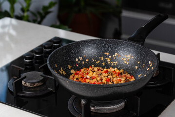 Close up of Chef cook hands cooking roasted onion, pepper, Shiitake mushrooms, cabbage, garlic in frying wok pan on gas stove.