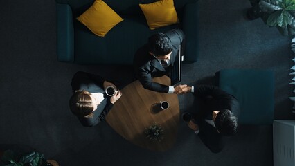 Top down aerial view of business people making agreement about collaborate business and shaking...
