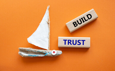 Build trust symbol. Wooden blocks with words Build trust. Beautiful orange background with boat. Business and Build trust concept. Copy space.
