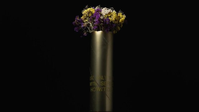 No war concept flowers in a vase made from militarry artillery ammunition casing shell guided artillery projectile EXCALIBUR
