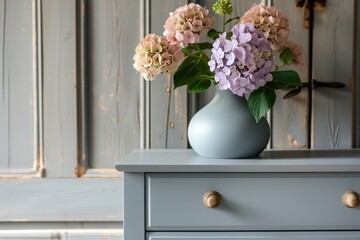 Fresh cut spring flowers in vase on chest of drawers in bedroom
