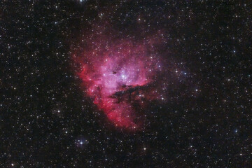 A pinkish red nebula in the space (Pacman nebula)