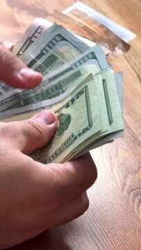 close-up of male hands counting a stack of hundred-dollar US banknotes. a businessman is counting cash. the concept of investment, money exchange, bribes or corruption. selective focus. High quality 4