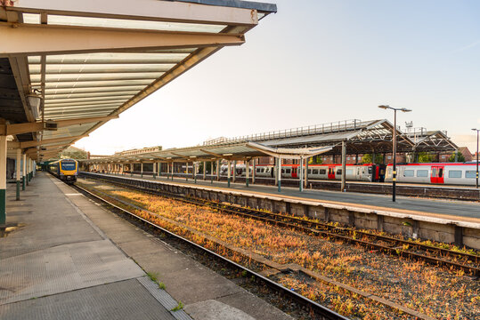 Modern diesel passenger trains in station at sunset