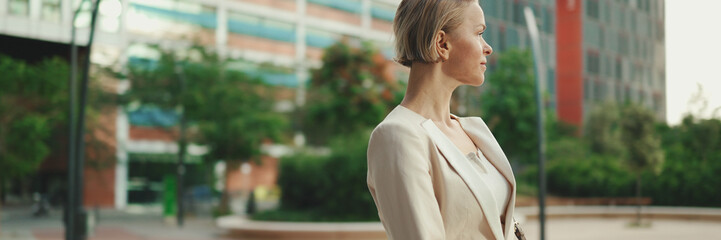 Businesswoman crosses her arms goes on the street, Panorama