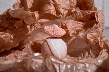 part of the peach bath bomb lies on top of the round bath bomb. Texture and close-up