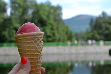 Karpacz, Poland. Ice cream cone with red scope with the Wild Waterfall (polish: Dziki Wodospad) –...