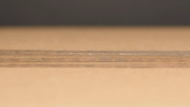Extreme close-up cardboard box sticky tape being quickly cut open left to right retractable blade knife