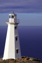 Lighthouse on a rocky outcrop overlooking the Atlantic Ocean on a sunny summer afternoon