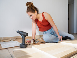 Focused Woman Assembling Furniture Following the Instructions