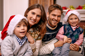 Christmas, portrait and happy family in home for holiday or festive celebration in lounge. Xmas, parents and face of children with hats in living room, bonding and kids together at party in house