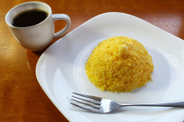 Couscous corn. Brazilian breakfast with coffee cup.