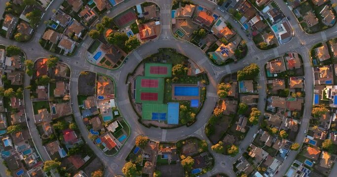 Aerial top down of contemporary houses in a suburb. Aerial view of American suburban neighborhood. Establishing shot of America's suburb, street. Residential single family houses, lush greenery
