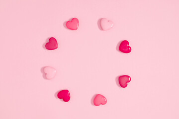 Wreath made of pink hearts on pastel pink background. Valentines day concept. Flat lay, top view, copy space