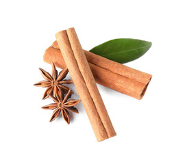 Cinnamon sticks, anise stars and green leaf isolated on white, above view