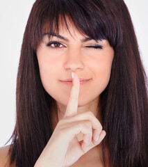 Naklejka premium Secret, wink and portrait of woman in studio with hand gesture for quiet, privacy or info. Gossip, emoji and face of girl with finger on mouth for confidential whisper, silence and white background.