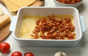 Cooking lasagna. Pasta sheets, minced meat in baking tray and products on white table, closeup