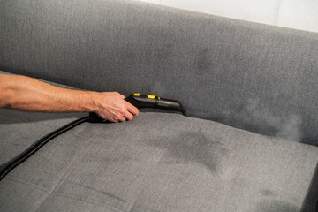 cleaning a gray sofa with steam