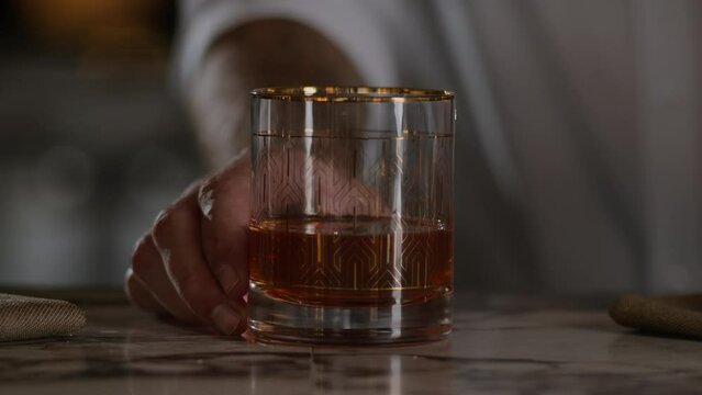 Bartender presents an old fashioned on top of the bar