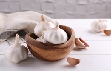 Fresh garlic on white wooden table, closeup. Space for text