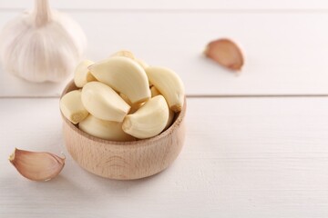 Fresh garlic on white wooden table, closeup. Space for text