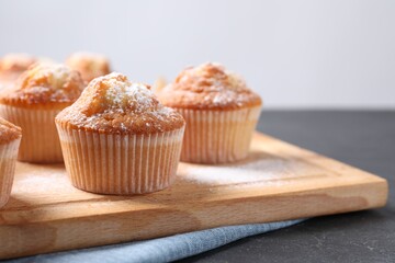 Delicious sweet muffins on black table, closeup. Space for text