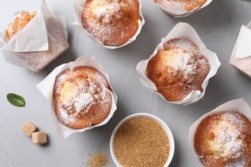 Delicious muffins on grey table, flat lay