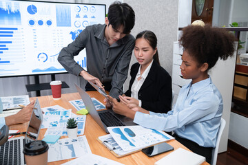 Multiracial analyst team use BI dashboard data to analyze financial report on meeting table. Group...